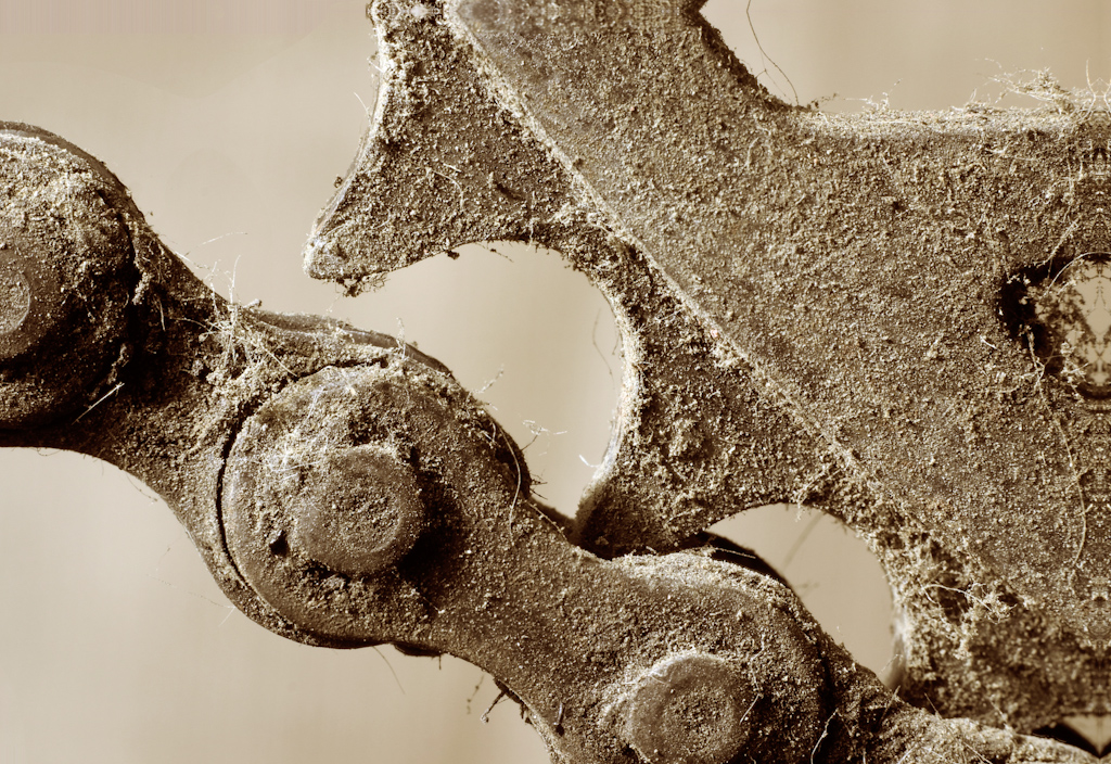 A close-up image of the chain and drive cog of an old rusted bicycle. The image is part of a series of photos of this bike, with each image concentrating on a different component.
